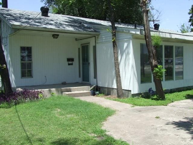 1729 Lindy Ln, Irving, TX 75060 - doorway to property featuring a yard and roof with shingles