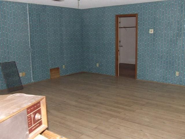 1729 Lindy Ln, Irving, TX 75060 - unfurnished room featuring wood finished floors and wallpapered walls