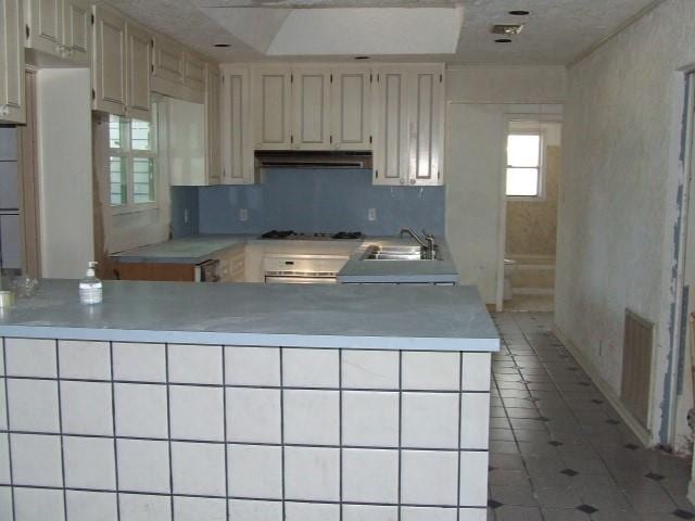 1729 Lindy Ln, Irving, TX 75060 - kitchen with under cabinet range hood, light countertops, wall oven, light tile patterned floors, and gas cooktop