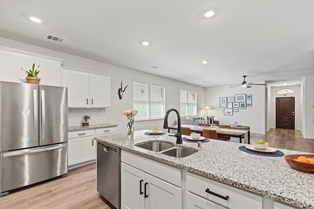 1512 Bennington Ln, Celina, TX 75009 - kitchen featuring appliances with stainless steel finishes, light wood finished floors, white cabinets, and recessed lighting