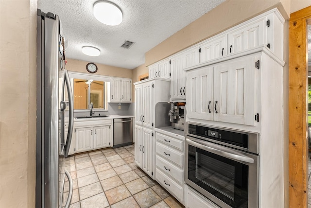 4610 County Road 862, Mckinney, TX 75071 - kitchen with stainless steel appliances, a textured ceiling, white cabinets, light countertops, and light stone finish floors
