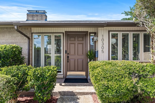 10305 Robindale Dr, Dallas, TX 75238 - entrance to property featuring a chimney, brick siding, and covered porch