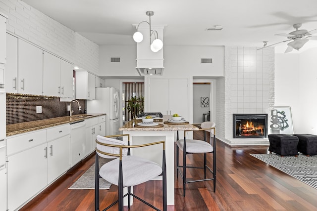 10305 Robindale Dr, Dallas, TX 75238 - kitchen with white appliances, ceiling fan, a fireplace, and dark wood-style floors