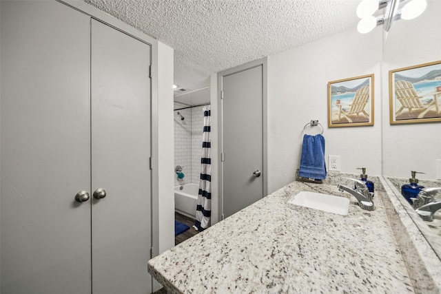 6050 Melody Ln Unit 107, Dallas, TX 75231 - bathroom with a textured ceiling, vanity, and shower / bathtub combination with curtain