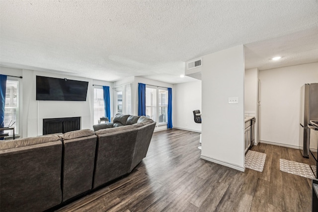 6050 Melody Ln Unit 107, Dallas, TX 75231 - living area with a textured ceiling, dark wood finished floors, and a fireplace