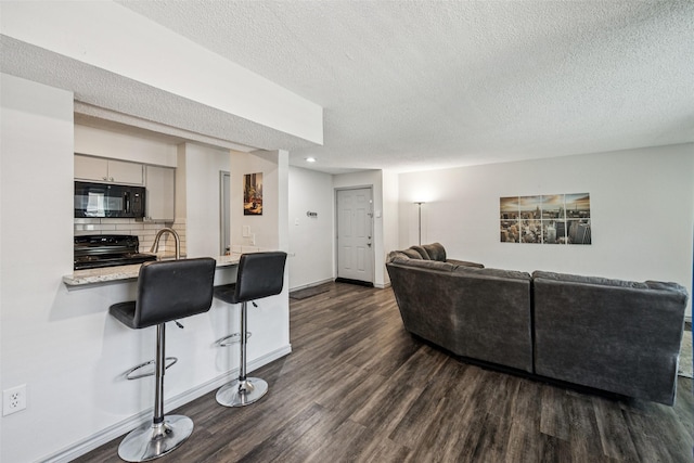 6050 Melody Ln Unit 107, Dallas, TX 75231 - living room with dark wood-style flooring, a textured ceiling, and recessed lighting