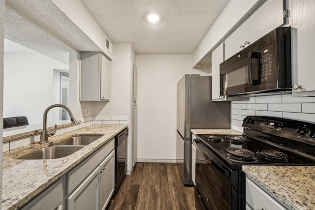 6050 Melody Ln Unit 107, Dallas, TX 75231 - kitchen featuring black appliances, a textured ceiling, dark wood-style floors, decorative backsplash, and light stone countertops