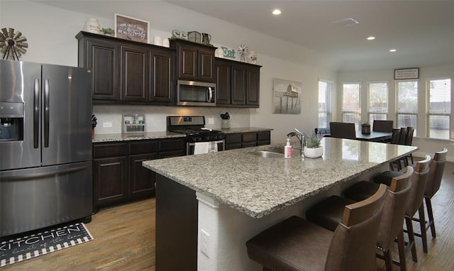 219 Spruce Valley Dr, Justin, TX 76247 - kitchen with stainless steel appliances, recessed lighting, light wood-type flooring, a kitchen breakfast bar, and a center island with sink