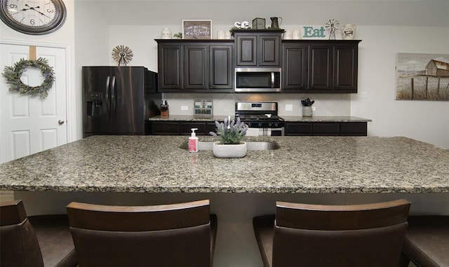 219 Spruce Valley Dr, Justin, TX 76247 - kitchen with appliances with stainless steel finishes, a breakfast bar area, a spacious island, and light stone counters