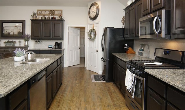 219 Spruce Valley Dr, Justin, TX 76247 - kitchen with stainless steel appliances, dark wood-style flooring, decorative backsplash, light stone countertops, and dark brown cabinets