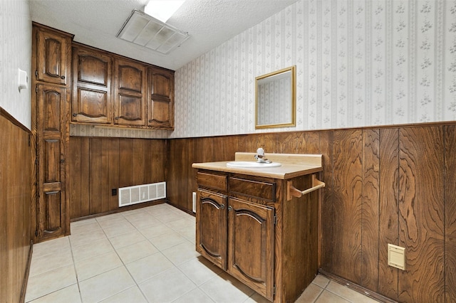 7220 Tucker Dr, Weatherford, TX 76085 - bathroom with wainscoting, vanity, tile patterned floors, wooden walls, and a textured ceiling