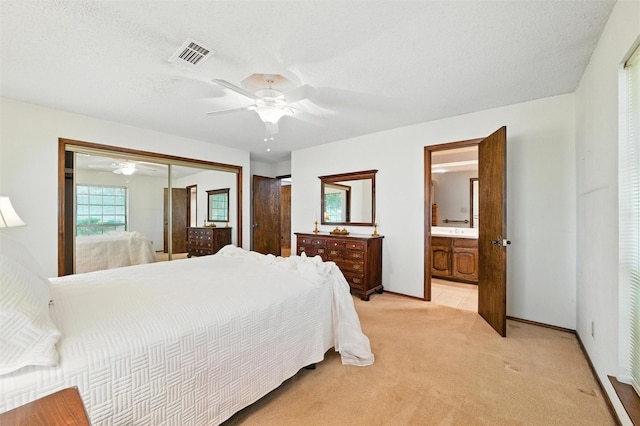 7220 Tucker Dr, Weatherford, TX 76085 - bedroom with light carpet, a closet, a ceiling fan, and connected bathroom