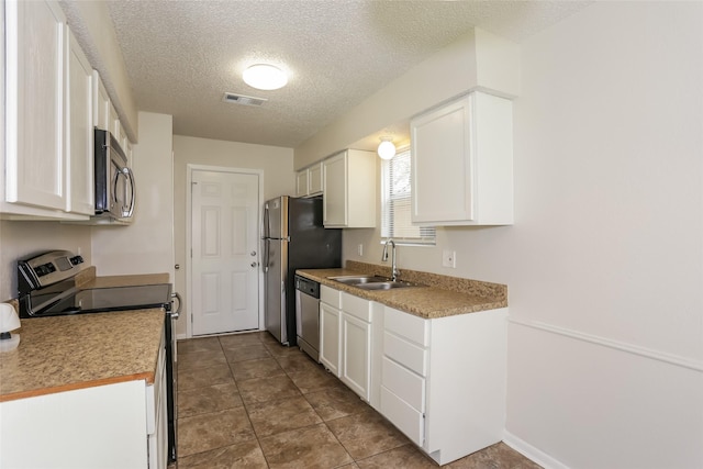 1209 Pin Oak Dr, Denton, TX 76209 - kitchen featuring stainless steel appliances, white cabinetry, a textured ceiling, and light countertops