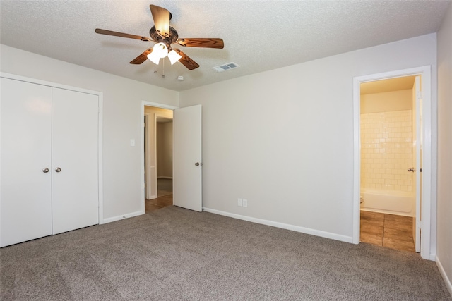 1209 Pin Oak Dr, Denton, TX 76209 - unfurnished bedroom with carpet, a textured ceiling, a closet, ensuite bath, and ceiling fan