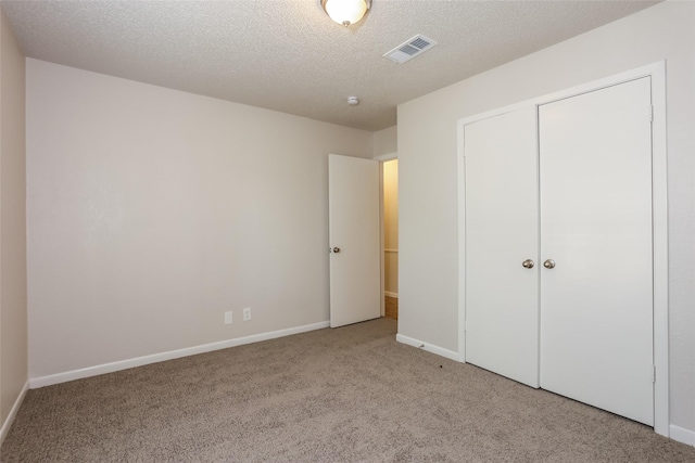 1209 Pin Oak Dr, Denton, TX 76209 - unfurnished bedroom featuring carpet floors, a textured ceiling, and a closet
