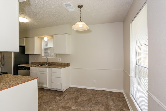 1209 Pin Oak Dr, Denton, TX 76209 - kitchen featuring stainless steel appliances, white cabinets, a textured ceiling, and decorative light fixtures