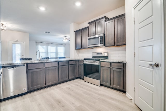 276 Jefferson Ln, Fate, TX 75189 - kitchen featuring appliances with stainless steel finishes, ceiling fan, light stone countertops, and recessed lighting