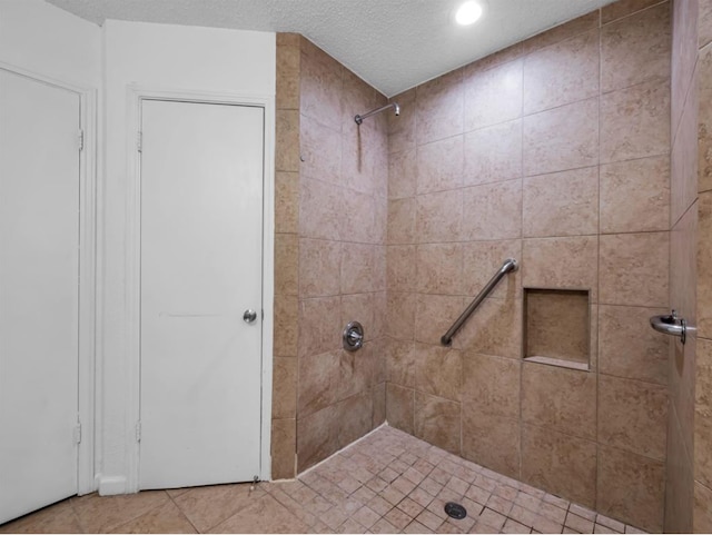 1013 Huntersglen Dr, Mesquite, TX 75150 - bathroom with a tile shower, recessed lighting, tile patterned floors, and a textured ceiling