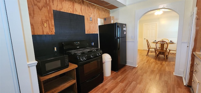 108 S Bonham St, Mexia, TX 76667 - kitchen with black appliances, arched walkways, and light wood finished floors