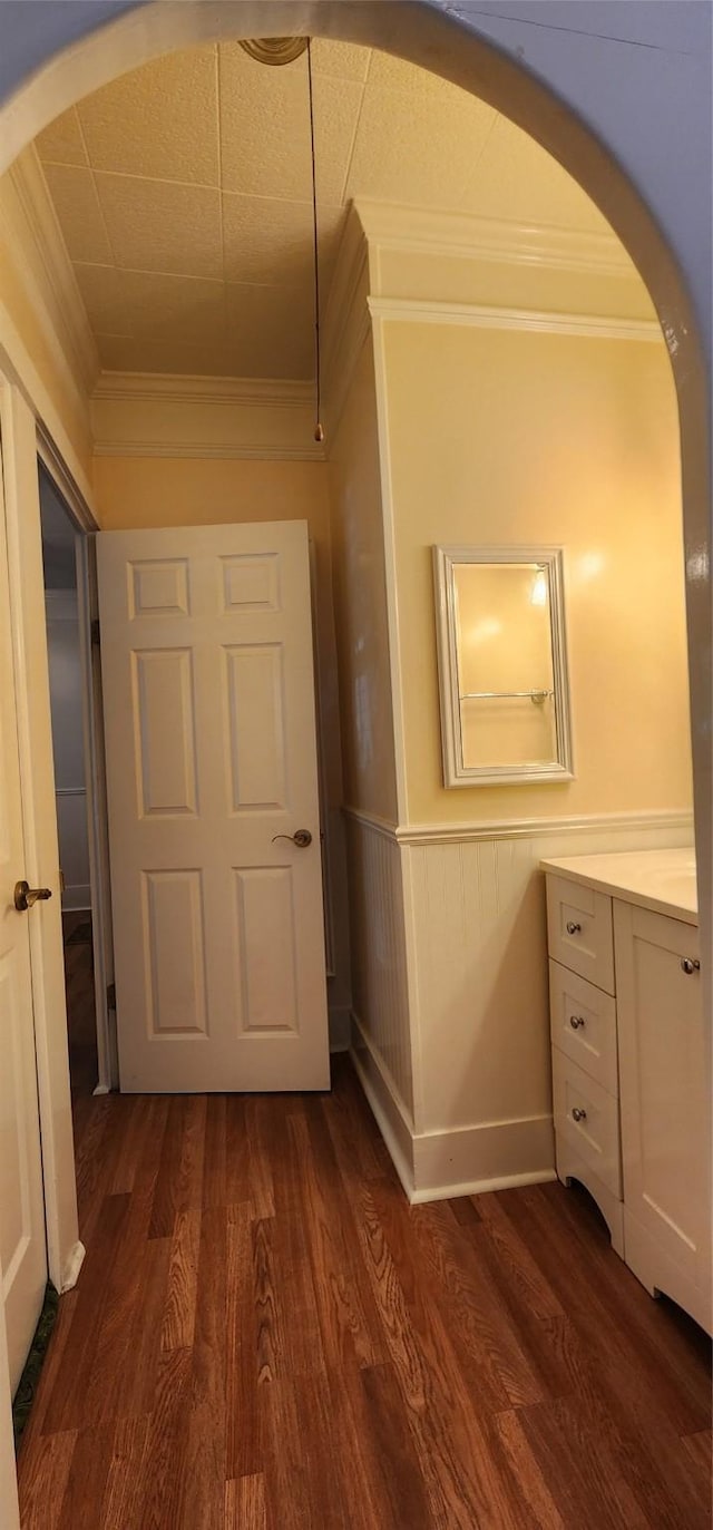 108 S Bonham St, Mexia, TX 76667 - corridor featuring crown molding, dark wood-style flooring, arched walkways, and wainscoting