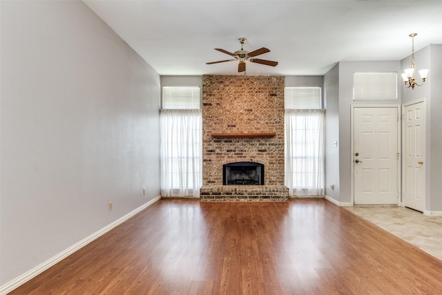 1524 Regent St, Mesquite, TX 75149 - unfurnished living room with a ceiling fan, wood finished floors, a chandelier, and a fireplace