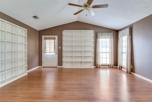1524 Regent St, Mesquite, TX 75149 - unfurnished room with light wood finished floors, lofted ceiling, a textured ceiling, ceiling fan, and built in shelves