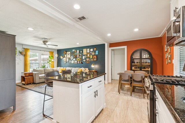 5029 Jerri Ln, Haltom City, TX 76117 - kitchen featuring appliances with stainless steel finishes, a kitchen bar, open floor plan, dark stone countertops, and recessed lighting