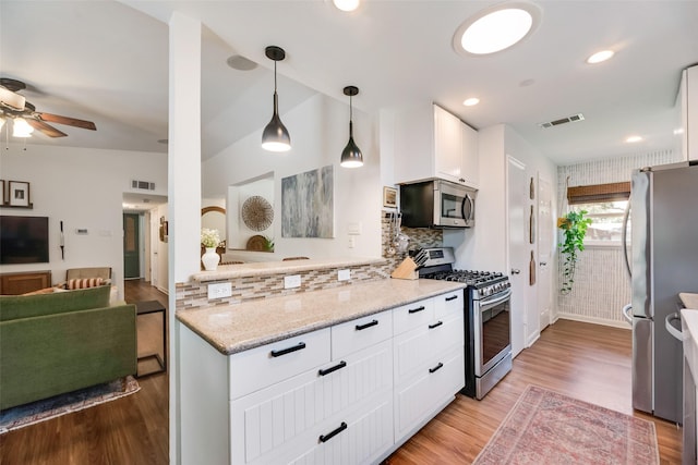 714 Silverstone Dr, Richardson, TX 75080 - kitchen featuring appliances with stainless steel finishes, ceiling fan, light wood-style flooring, white cabinetry, and hanging light fixtures