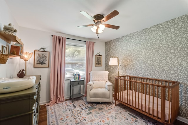 714 Silverstone Dr, Richardson, TX 75080 - bedroom featuring wallpapered walls, a crib, wood finished floors, and ceiling fan