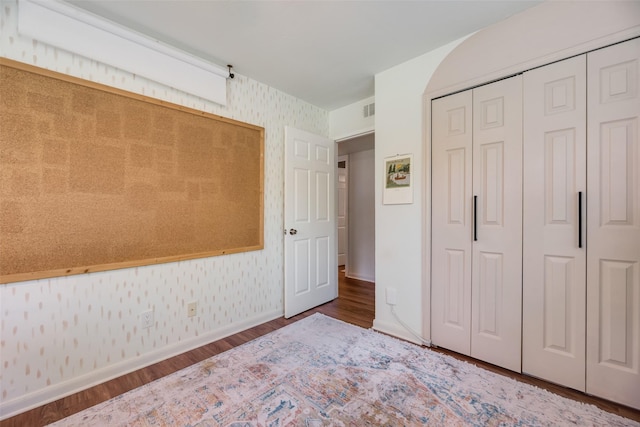 714 Silverstone Dr, Richardson, TX 75080 - bedroom with wallpapered walls, wood finished floors, and a closet