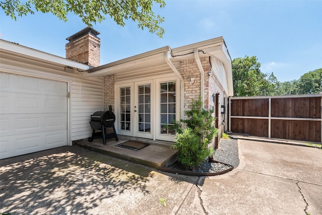 714 Silverstone Dr, Richardson, TX 75080 - back of house featuring french doors, a chimney, driveway, and a garage