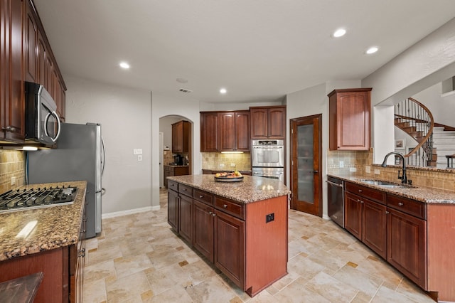 1829 Lewis Crossing Dr, Keller, TX 76248 - kitchen featuring appliances with stainless steel finishes, arched walkways, decorative backsplash, a kitchen island, and recessed lighting