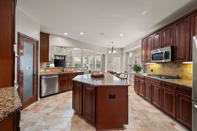 1829 Lewis Crossing Dr, Keller, TX 76248 - kitchen with stainless steel appliances, decorative backsplash, a center island, dark stone countertops, and a chandelier
