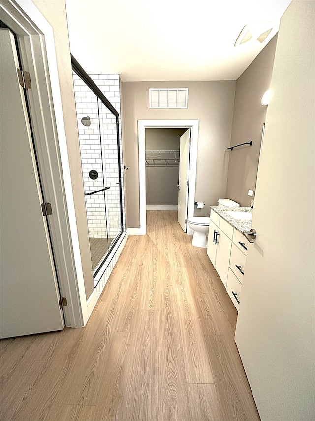 3517 Windhaven Pkwy Unit 1209, Lewisville, TX 75056 - bathroom featuring vanity, a stall shower, wood finished floors, and a walk in closet