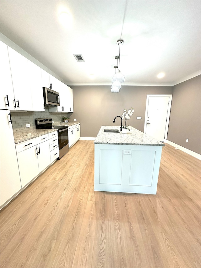 3517 Windhaven Pkwy Unit 1209, Lewisville, TX 75056 - kitchen with appliances with stainless steel finishes, white cabinetry, light wood-style floors, tasteful backsplash, and hanging light fixtures