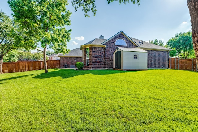 8600 Digby Dr, Plano, TX 75025 - rear view of house with a fenced backyard, a storage shed, brick siding, a chimney, and roof with shingles