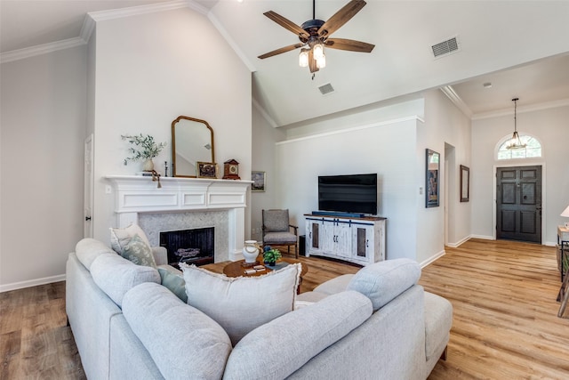 8600 Digby Dr, Plano, TX 75025 - living area with light wood-type flooring, a fireplace, a ceiling fan, high vaulted ceiling, and crown molding