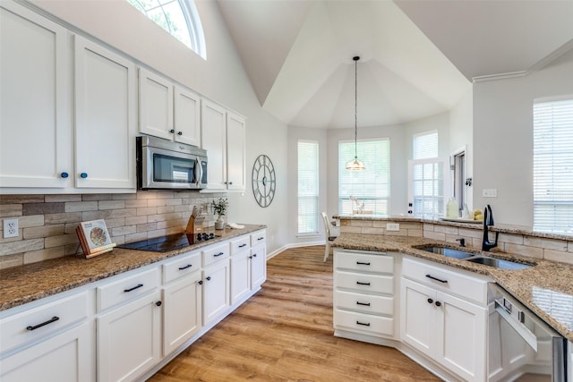 8600 Digby Dr, Plano, TX 75025 - kitchen featuring appliances with stainless steel finishes, backsplash, white cabinets, light wood finished floors, and vaulted ceiling