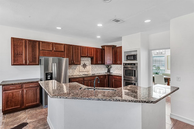 2904 Champlin Ct, Richardson, TX 75082 - kitchen featuring stainless steel appliances, dark stone counters, decorative backsplash, a kitchen island with sink, and recessed lighting