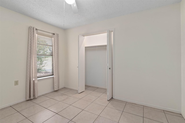 1509 Jefferson St, Bowie, TX 76230 - unfurnished bedroom featuring a textured ceiling, a closet, light tile patterned floors, and ceiling fan