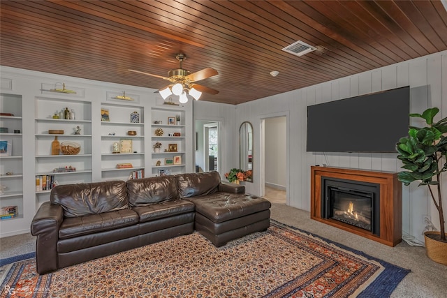 3933 Baltimore Ave, Shreveport, LA 71106 - carpeted living room featuring built in shelves, a glass covered fireplace, a ceiling fan, and wooden ceiling