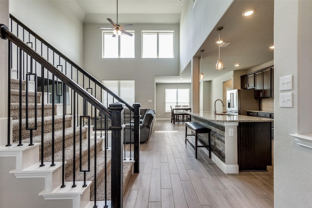 11825 Wulstone Rd, Fort Worth, TX 76052 - stairway with ceiling fan, wood finished floors, and a towering ceiling