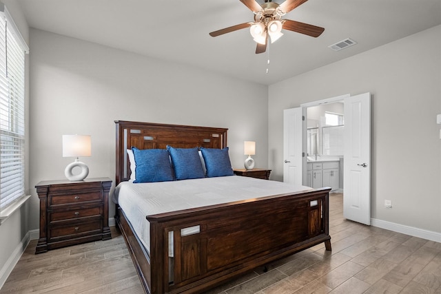 171 Tanager Dr, Rhome, TX 76078 - bedroom featuring multiple windows, light wood-type flooring, ensuite bath, and a ceiling fan