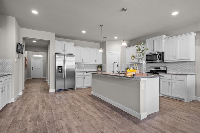 171 Tanager Dr, Rhome, TX 76078 - kitchen featuring appliances with stainless steel finishes, backsplash, light wood-style floors, recessed lighting, and white cabinets