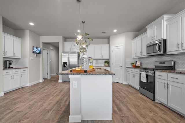 171 Tanager Dr, Rhome, TX 76078 - kitchen with appliances with stainless steel finishes, tasteful backsplash, wood finished floors, recessed lighting, and dark stone countertops