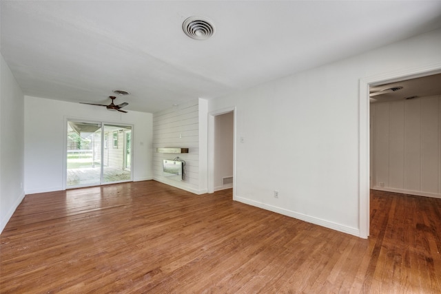 917 W Washington St, Sherman, TX 75092 - unfurnished living room with wood finished floors, a fireplace, and a ceiling fan