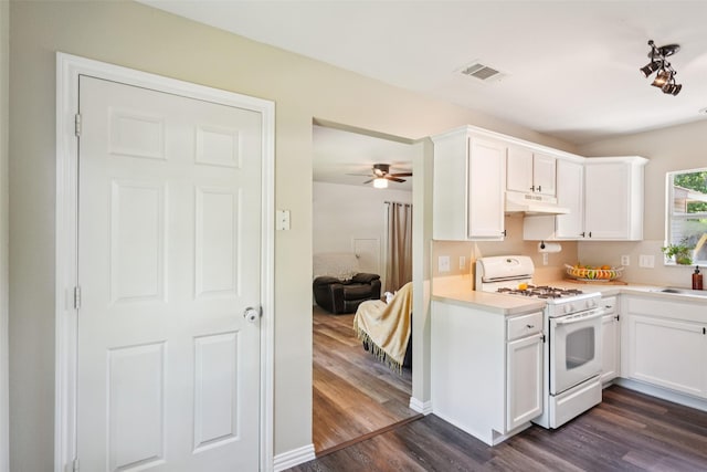 312 Robertson St, Denton, TX 76205 - kitchen with white range with gas cooktop, under cabinet range hood, dark wood-type flooring, light countertops, and white cabinets