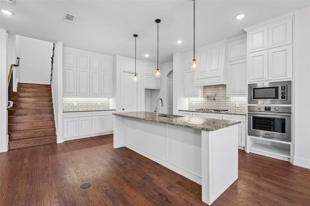 2604 Silverado Trl, Sherman, TX 75092 - kitchen with stainless steel appliances, tasteful backsplash, dark wood finished floors, recessed lighting, and dark stone countertops