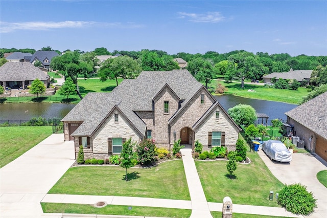 2604 Silverado Trl, Sherman, TX 75092 - french provincial home with stone siding, a water view, and concrete driveway
