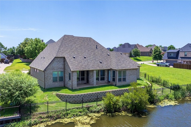 2604 Silverado Trl, Sherman, TX 75092 - back of property featuring brick siding, a water view, a fenced backyard, and a shingled roof